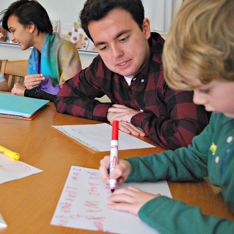 Upper School students at Chase Collegiate help younger students with writing.